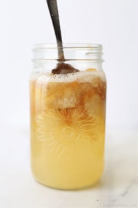apple cider to vinegar with fresh apples and water in a jar with a spoon