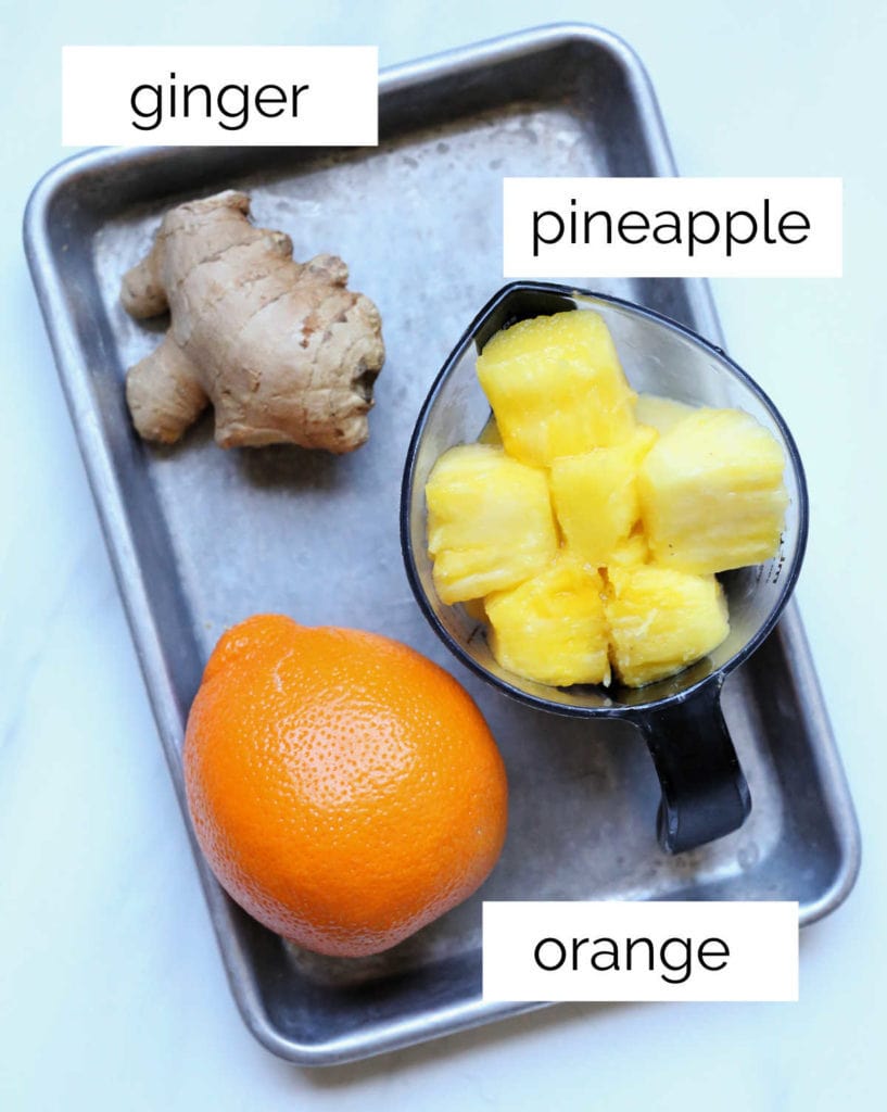 ginger pineapple chunks and one orange on a metal tray