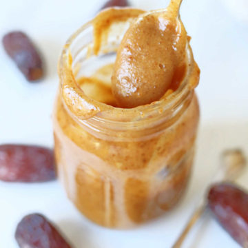 caramel sauce scooped with a spoon out of a mason jar and medjool dates around the jar