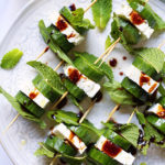 cucumber feta and herbs with balsamic drizzle served on toothpicks as an appetizer