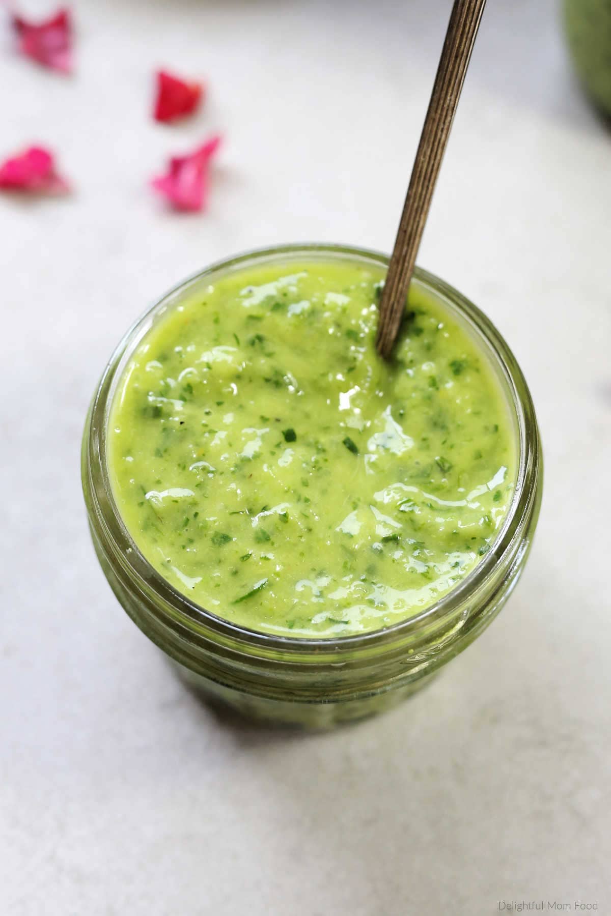 creamy avocado green goddess dressing in a mason jar with a spoon to serve as dip