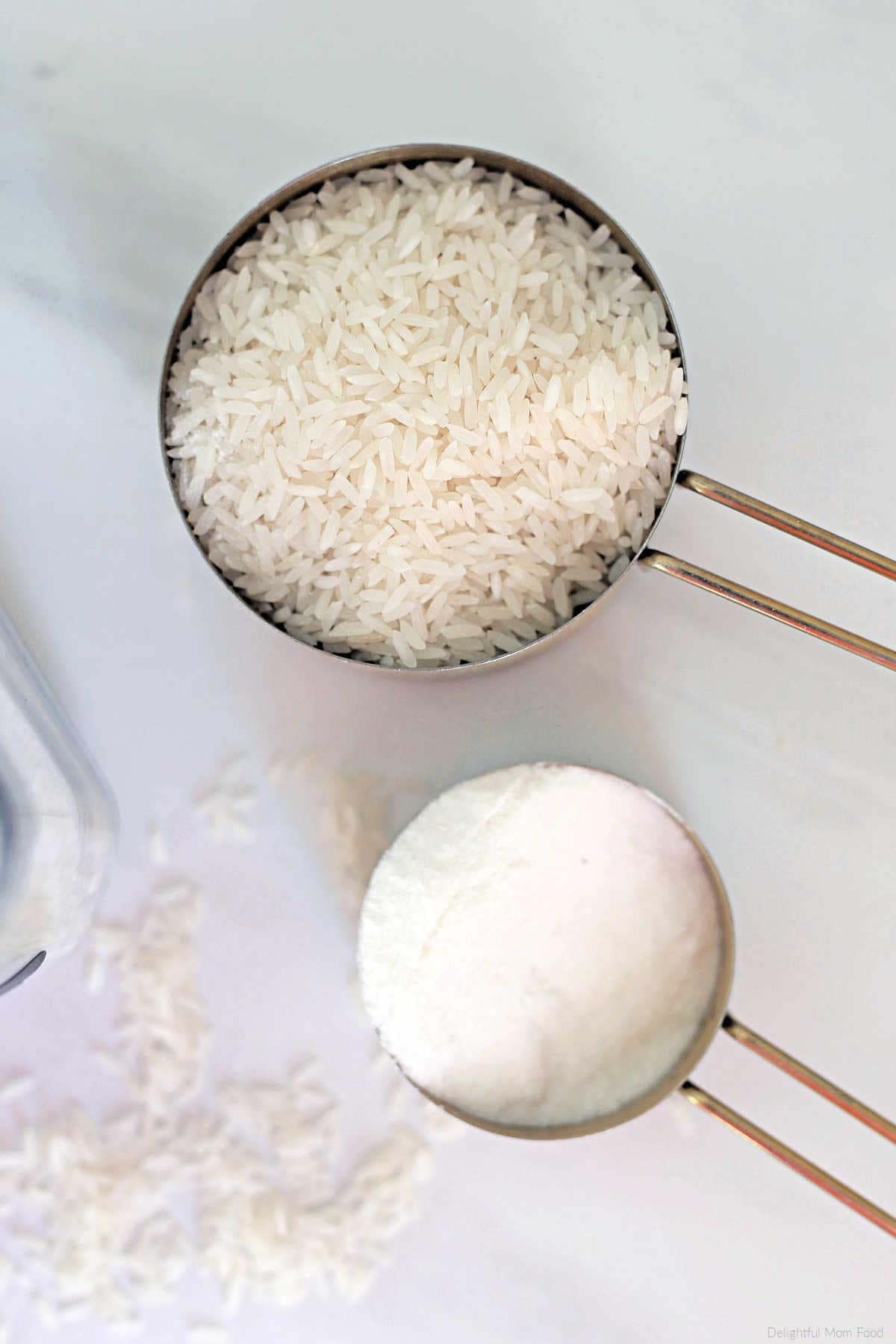 white rice grains in a measuring cup and rice flour in a measuring cup