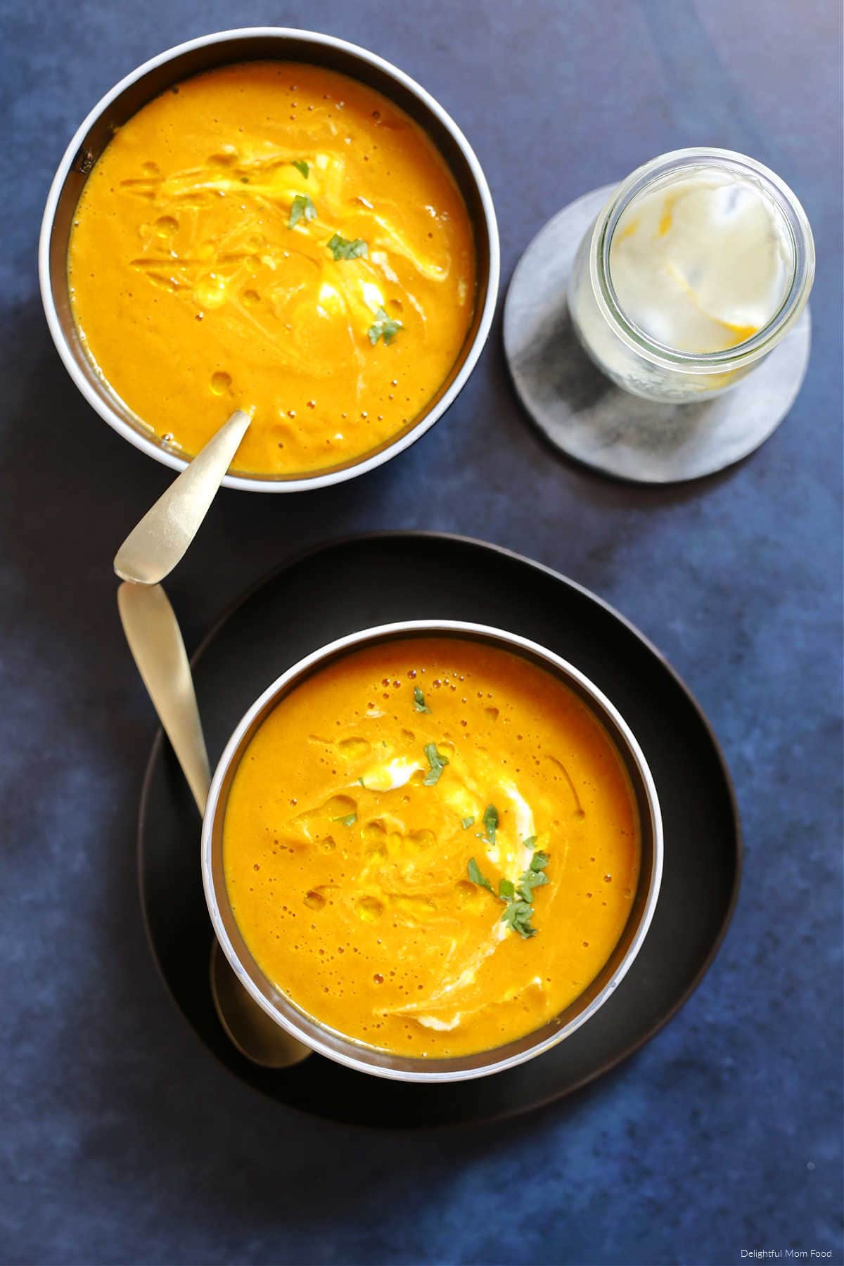 pumpkin soup recipe in a bowl with dairy-free yogurt, olive oil, and parsley stirred in