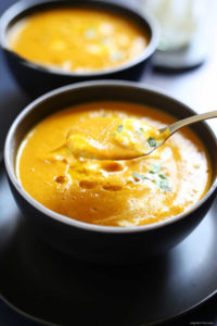 easy soup made with canned pumpkin and without cream in a bowl with a gold spoon