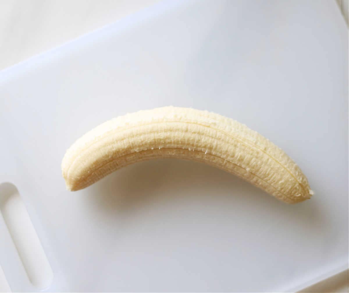 peeled banana on a cutting board