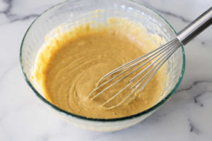 gluten-free pumpkin pancake batter in a bowl with a whisk
