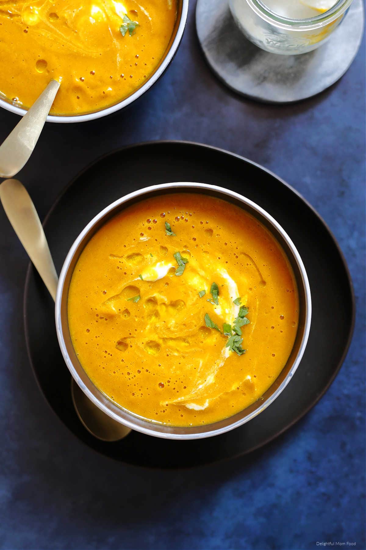 healthy pumpkin soup with olive oil drizzle in a bowl with a spoon