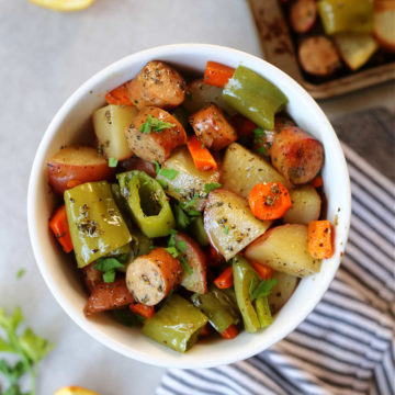 Sheet pan sausage and veggies roasted and served in a bowl.