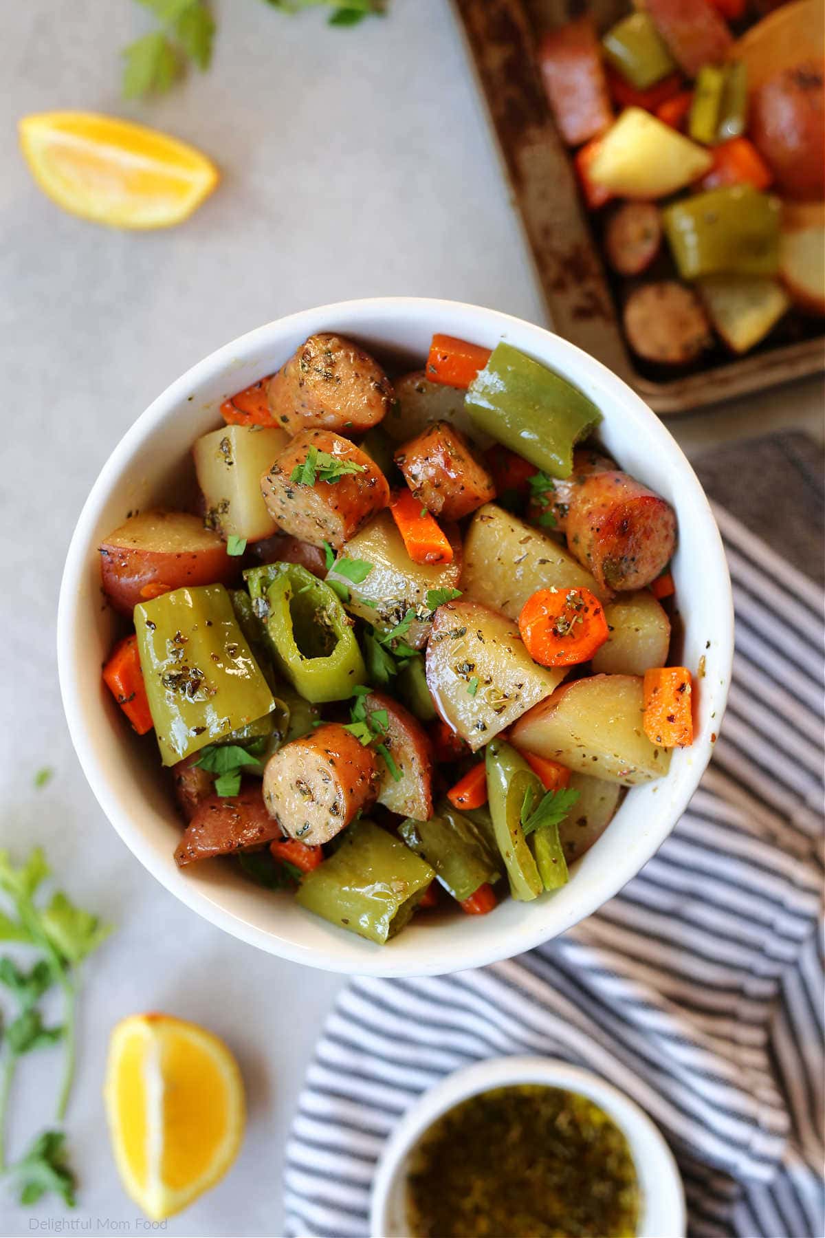 Sheet pan sausage and veggies roasted and served in a bowl.