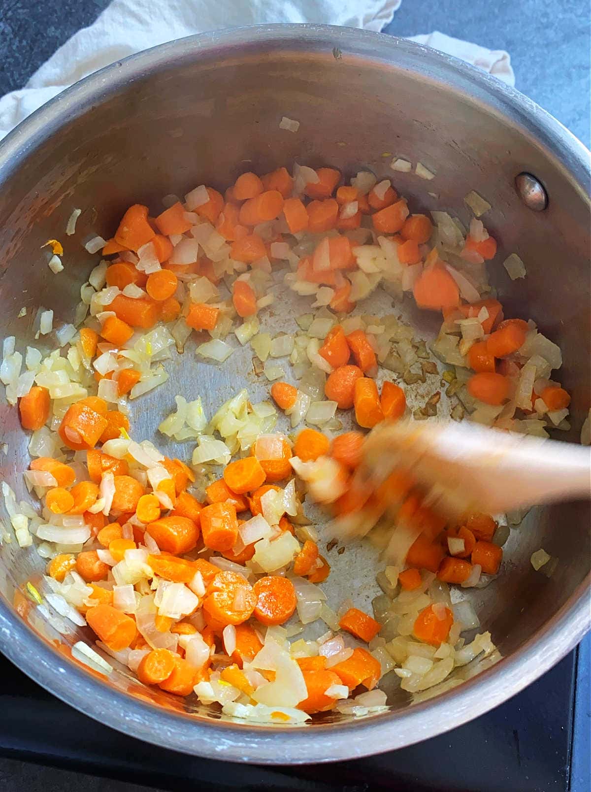 sauteed carrots onion garlic in a pot for soup