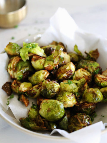 Air fry brussels sprouts on parchment paper in a dish