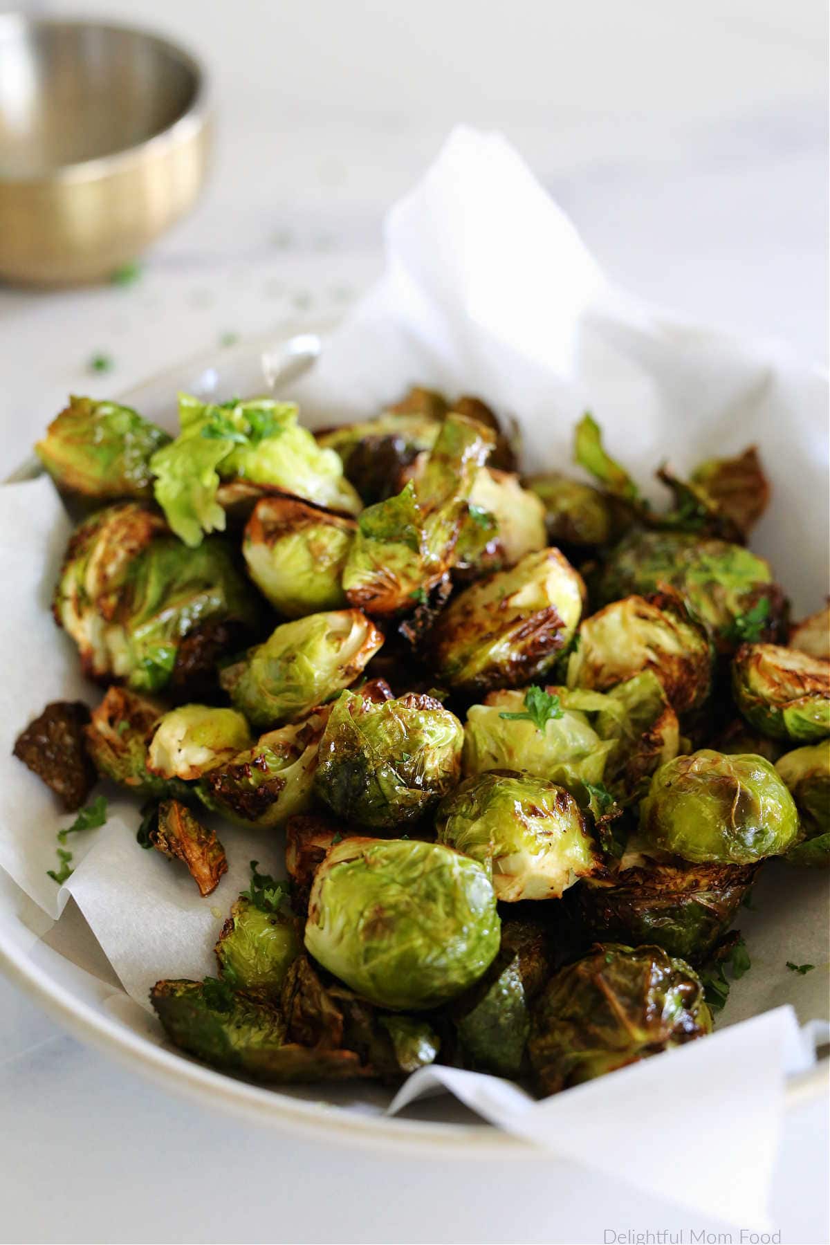Air fry brussels sprouts on parchment paper in a dish