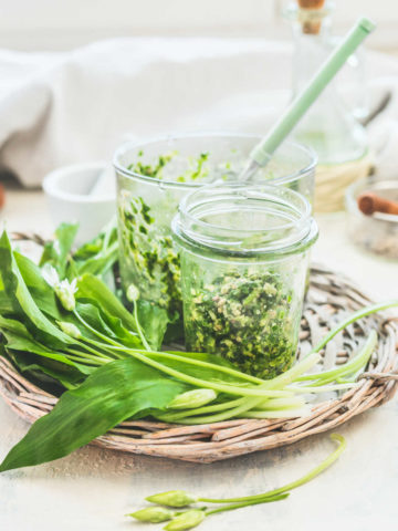 wild garlic leaves and bulbs made into pesto served in a glass jar