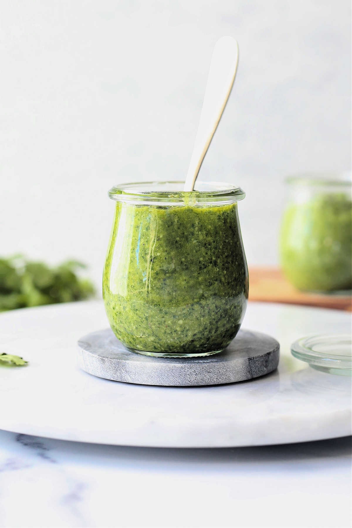 pesto made of cilantro and basil in a jar with a spoon