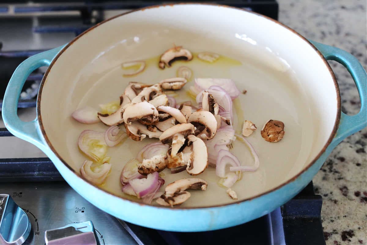 Mushroom and shallots in a saucepan.