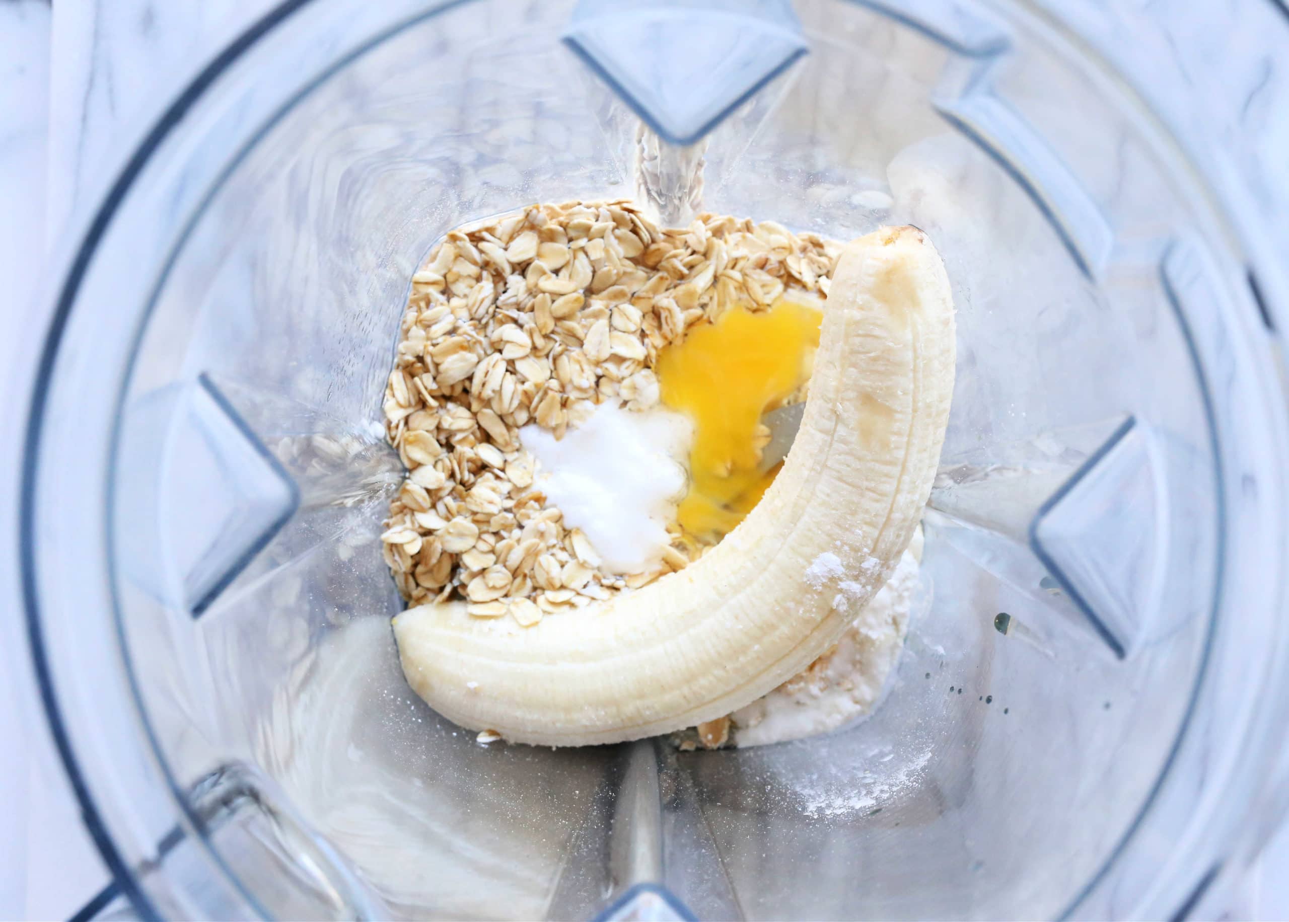 Banana, oats, egg and baking powder in a blender before blending.