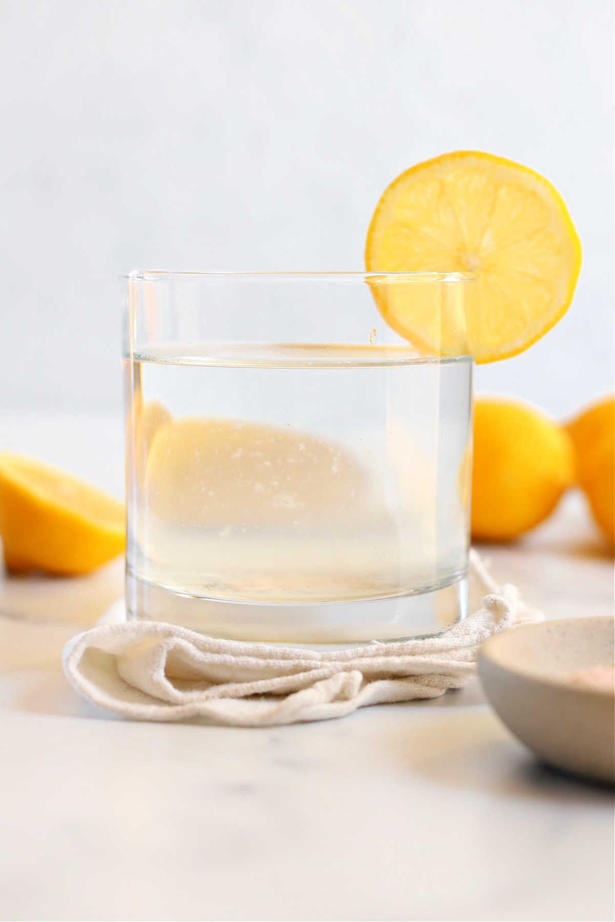 lemon salt water drink in a glass with a slice of lemon