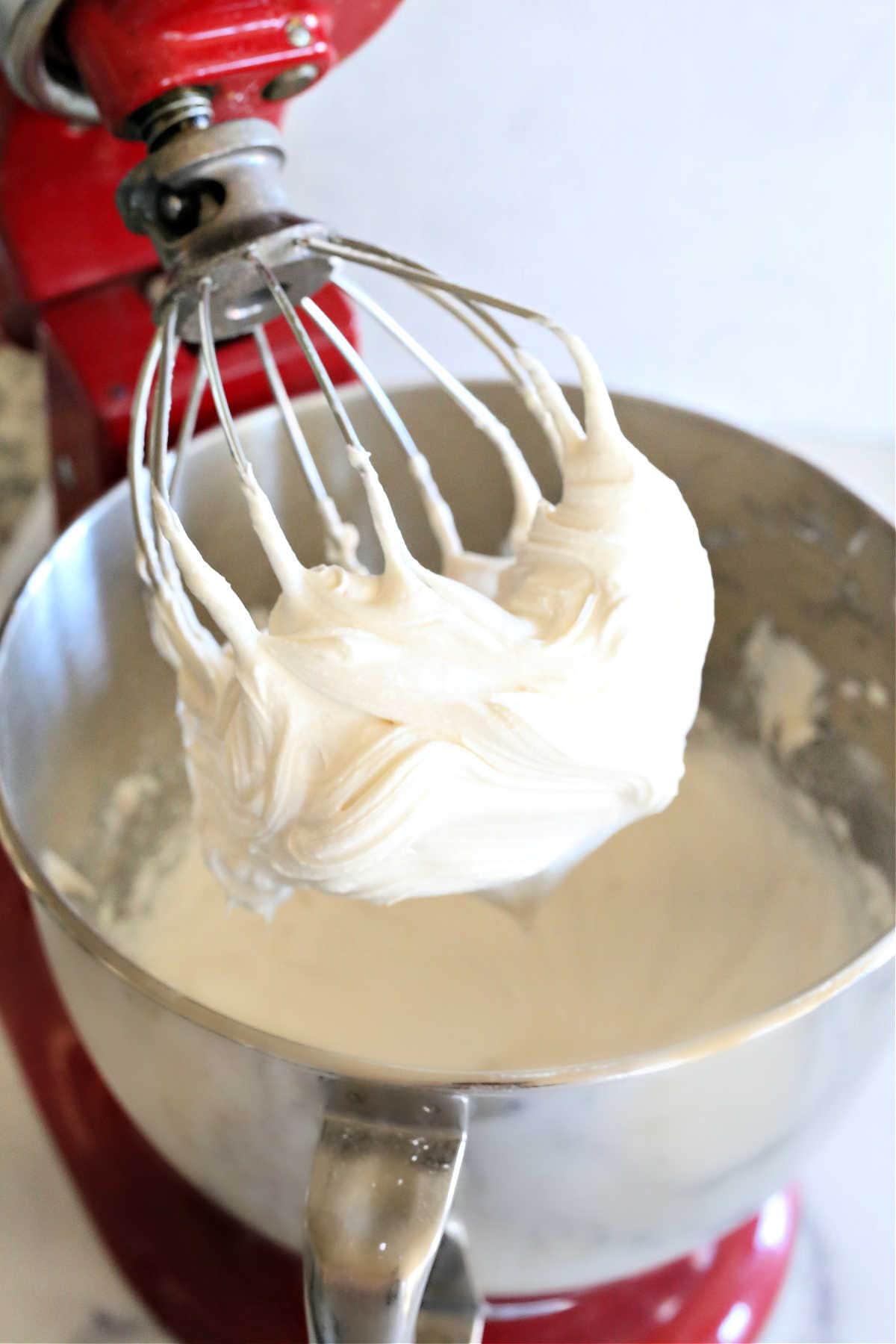 cream cheese buttercream icing on an electric mixer whisk