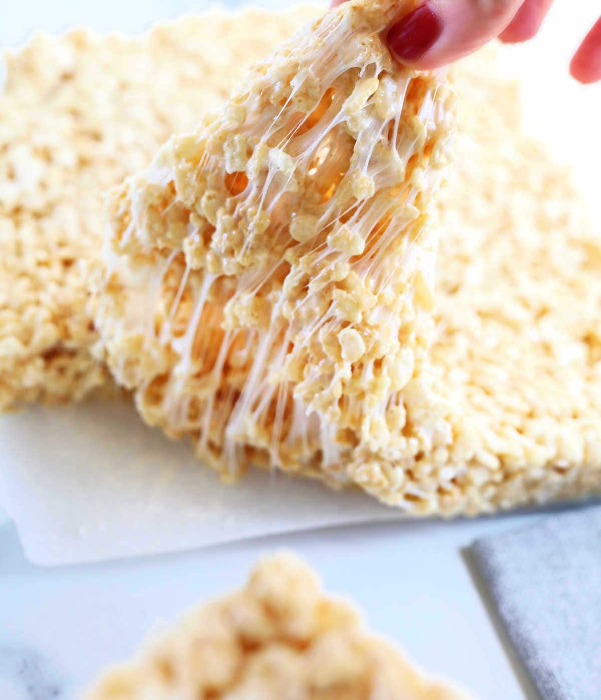 pulling apart homemade rice krispy treats with melted gooey vegan marshmallows stretching