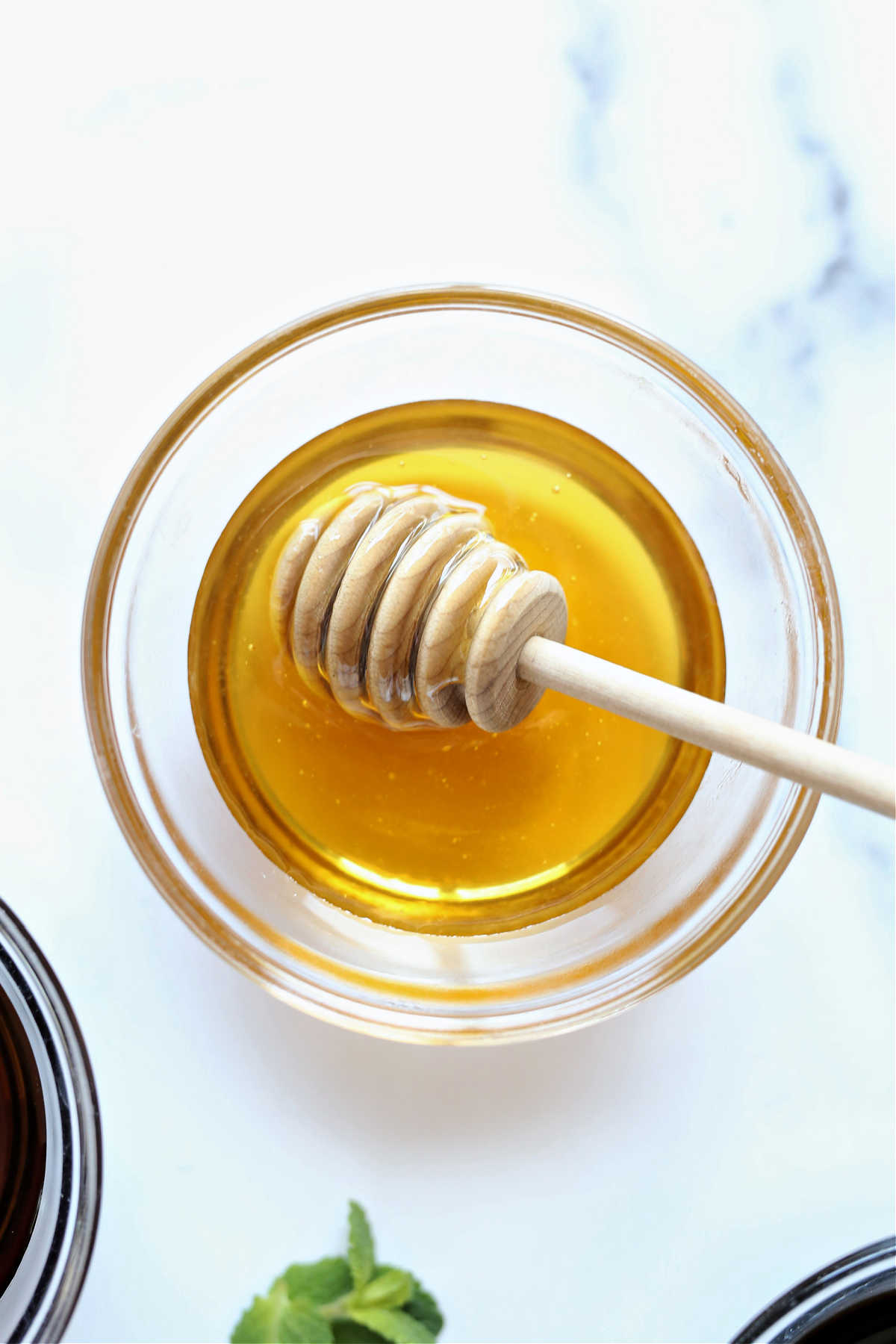 honey in a bowl with a honey stick to substitute for maple syrup
