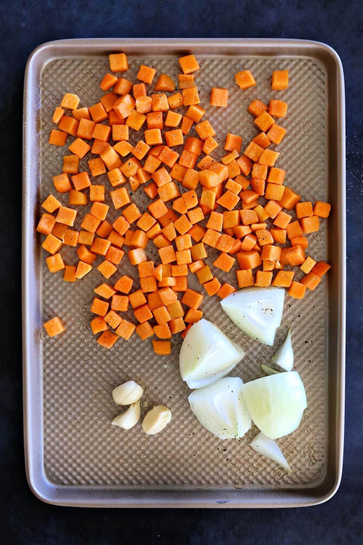roasted butternut squash, onion and garlic on a baking sheet to make sauce