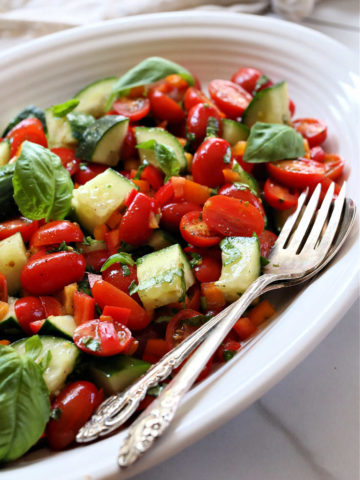 tomato and cucumber salad with serving spoons