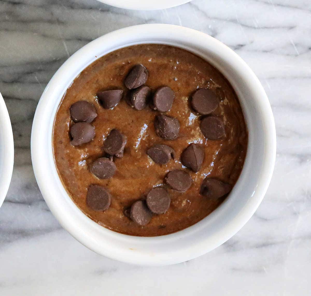 chocolate baked oats batter with chocolate chips on top in a ramekin