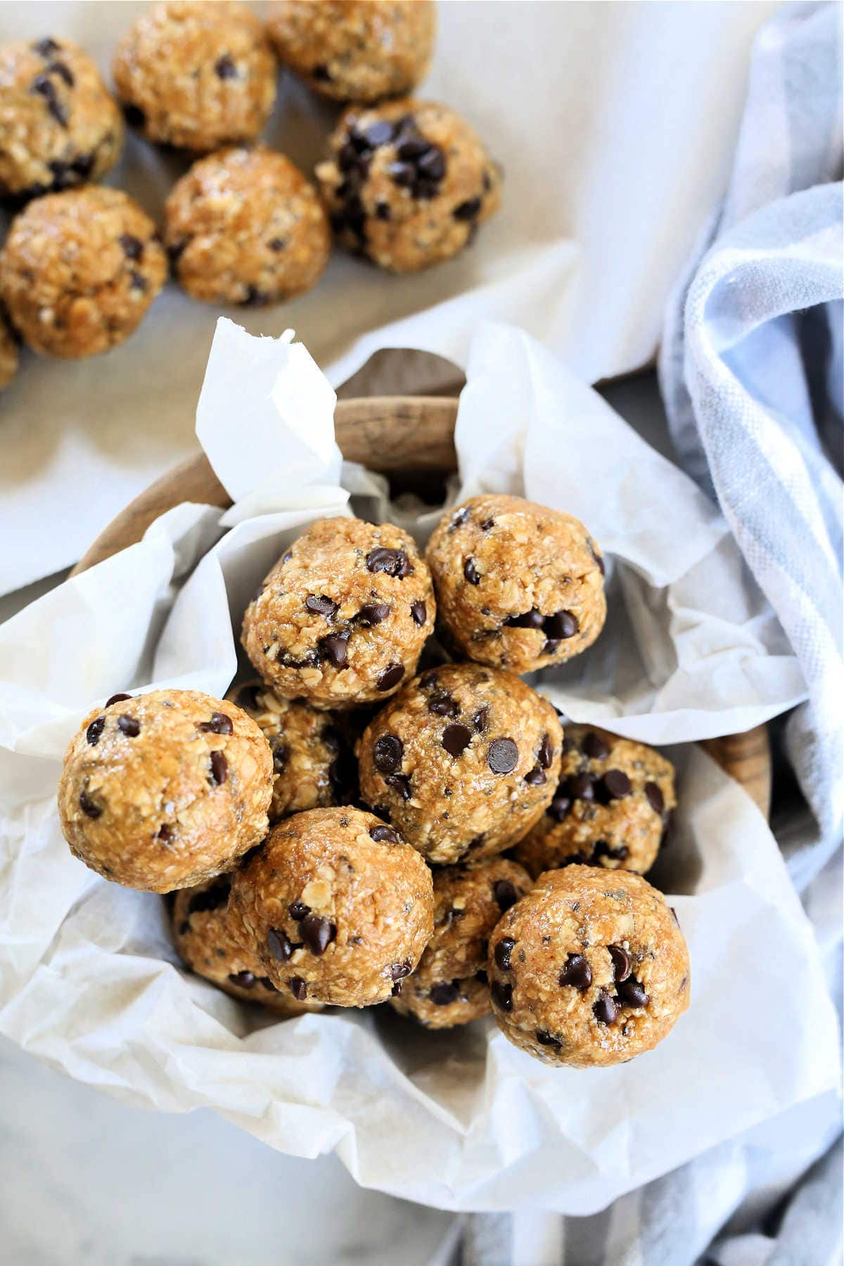 bunch of homemade no-bake protein balls in a bowl lined with parchment paper