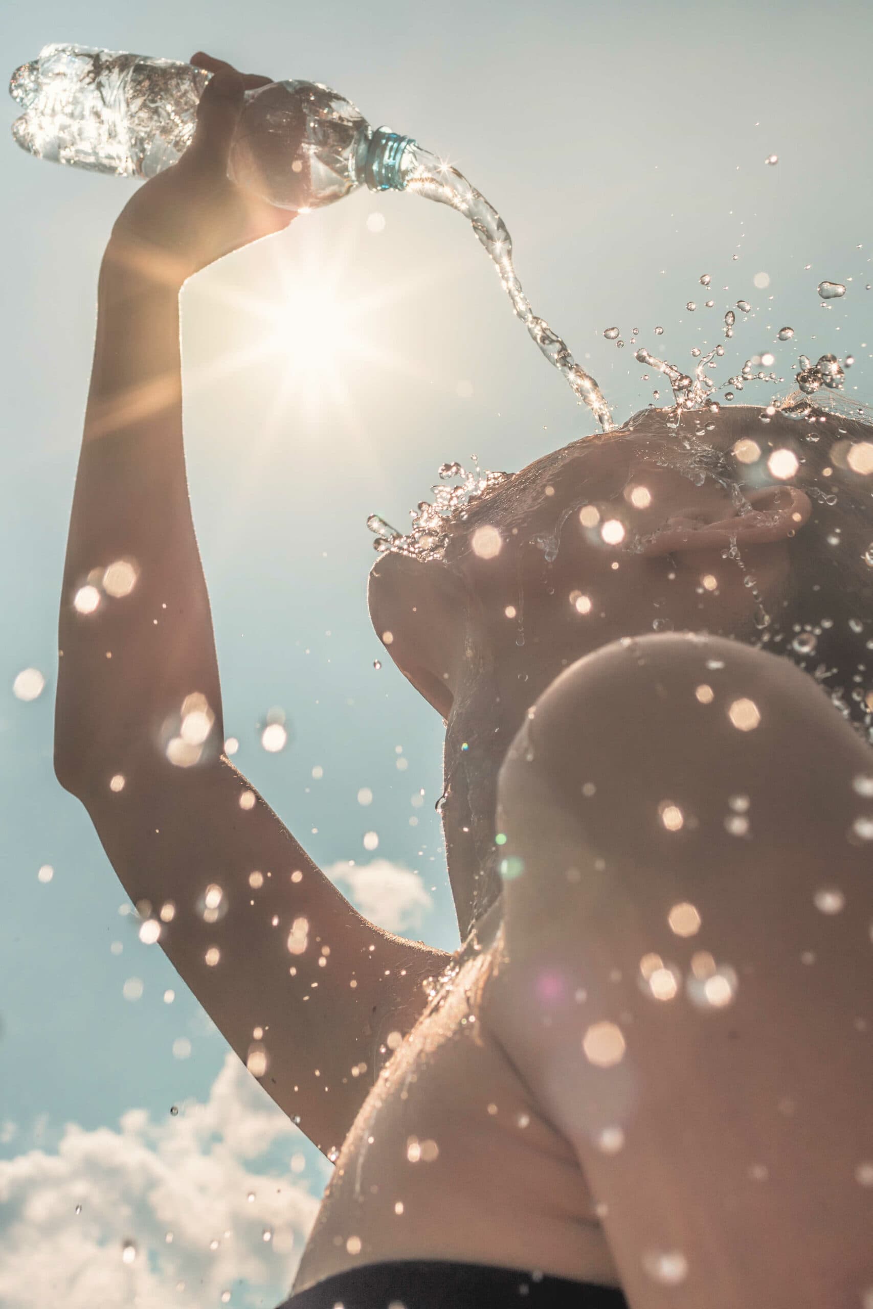 woman pouring water over face to cool off in the summer heat