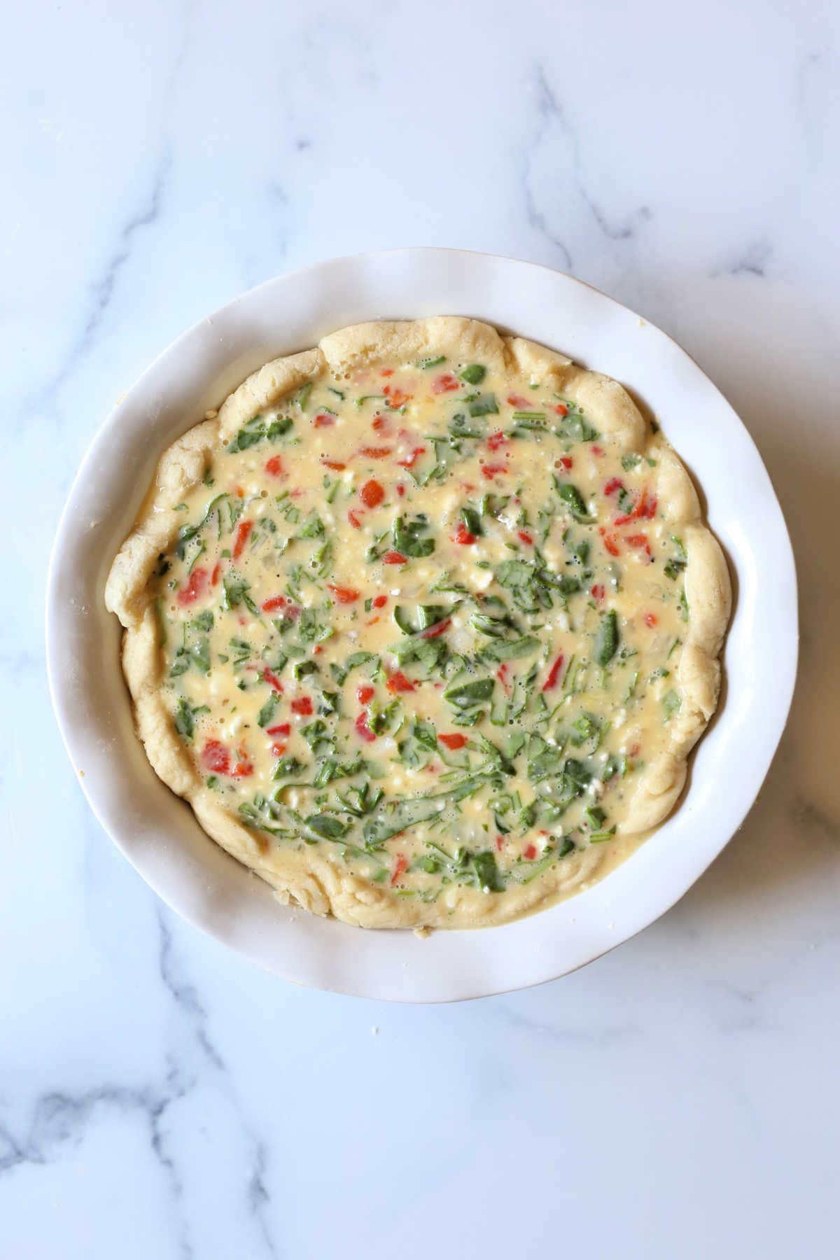 gluten free pie crust filled with spinach quiche filling