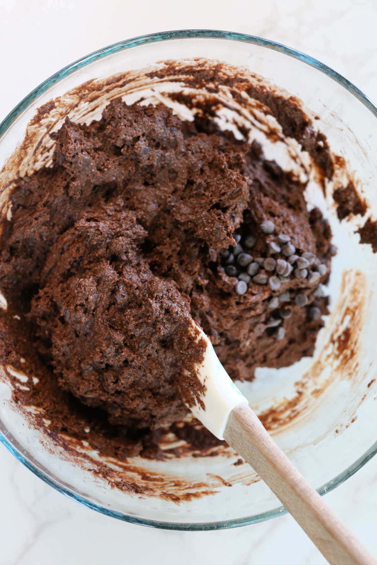 flourless chocolate muffin batter made with gluten-free oat flour in a bowl with a spatula