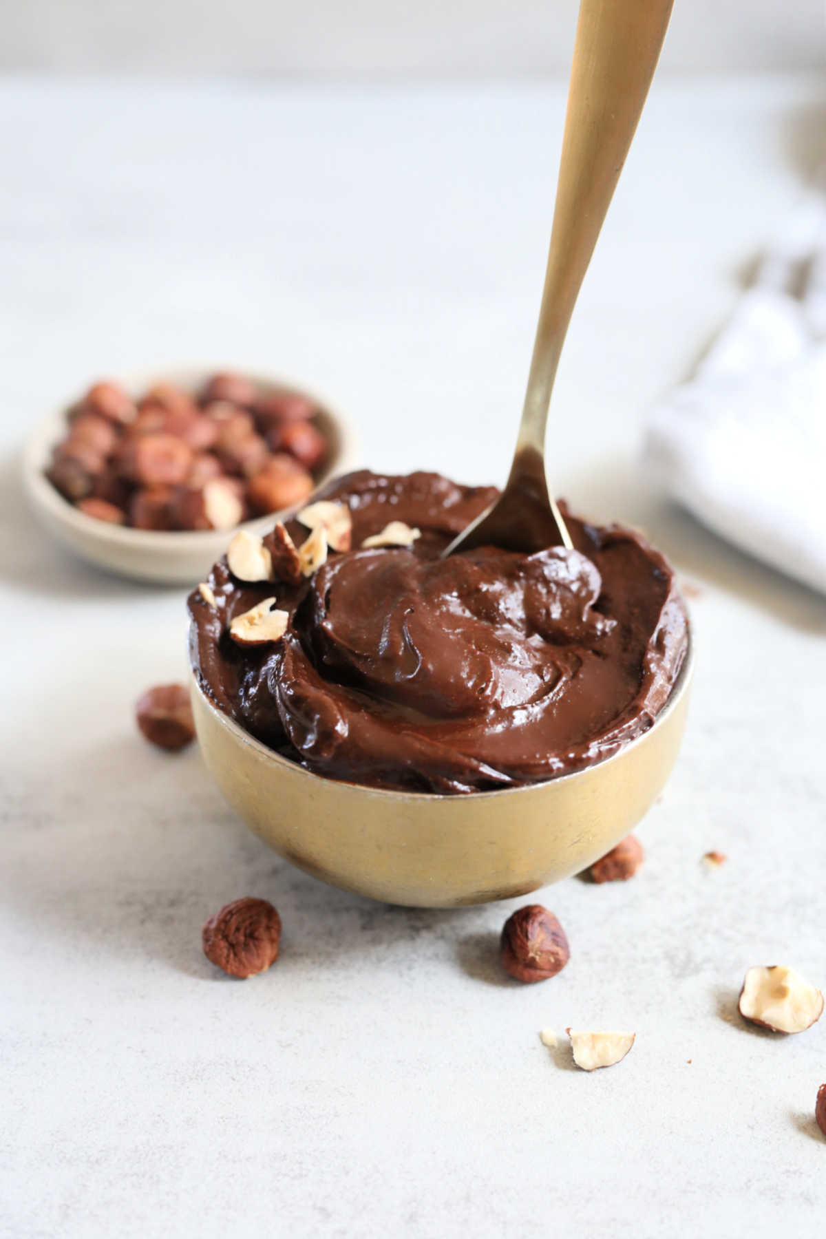 healthy chocolate hazelnut spread made from scratch at home in a gold bowl with a spoon