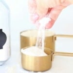 hand sifting heat treat flour from measuring cup