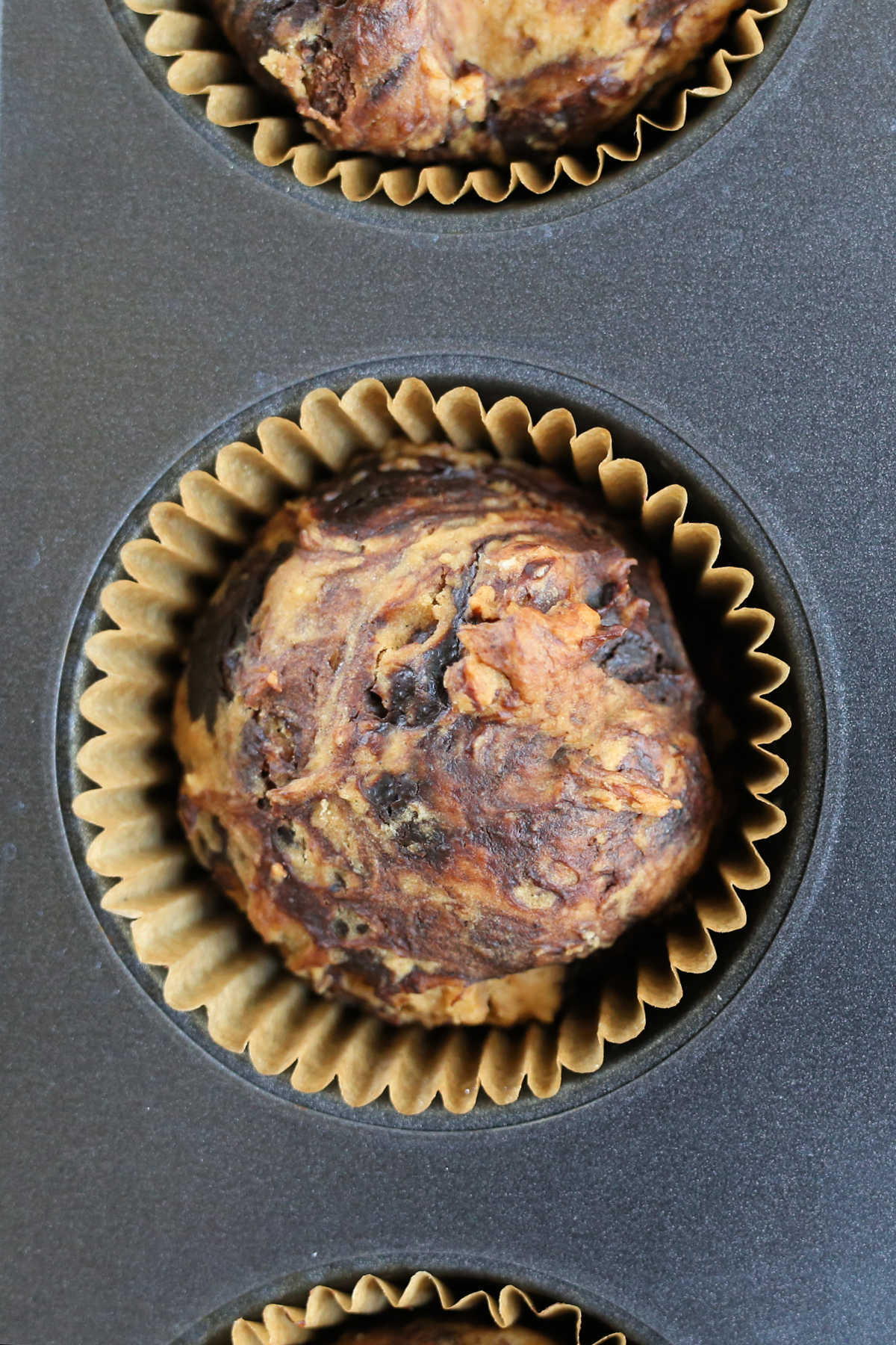 nutella muffins in a muffin pan made with swirls of chocolate hazelnut spread creating marble effect