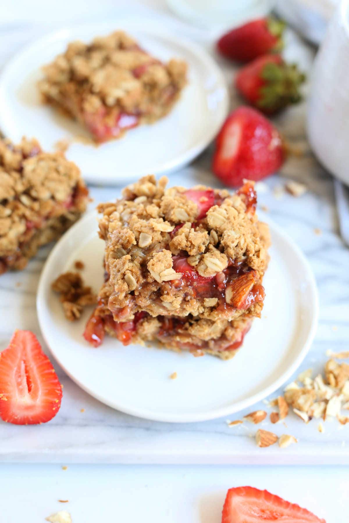 gluten-free crumble bars made with strawberry jam and fresh strawberries on a plate