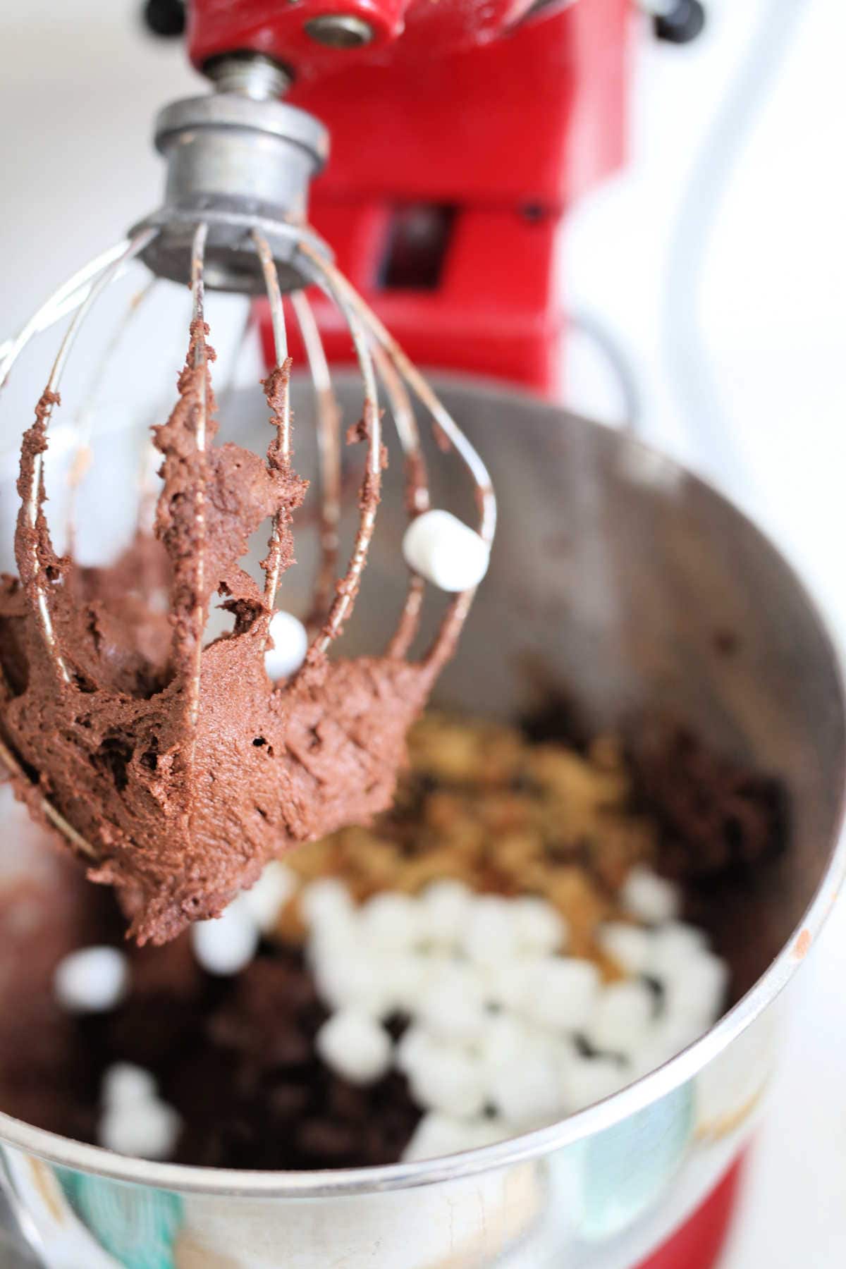chocolate marshmallow nut cookie batter on an electric mixer whisk