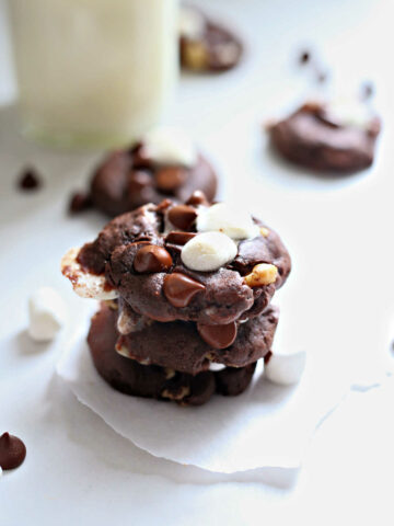 best rocky road cookies stacked on a table with a glass of milk