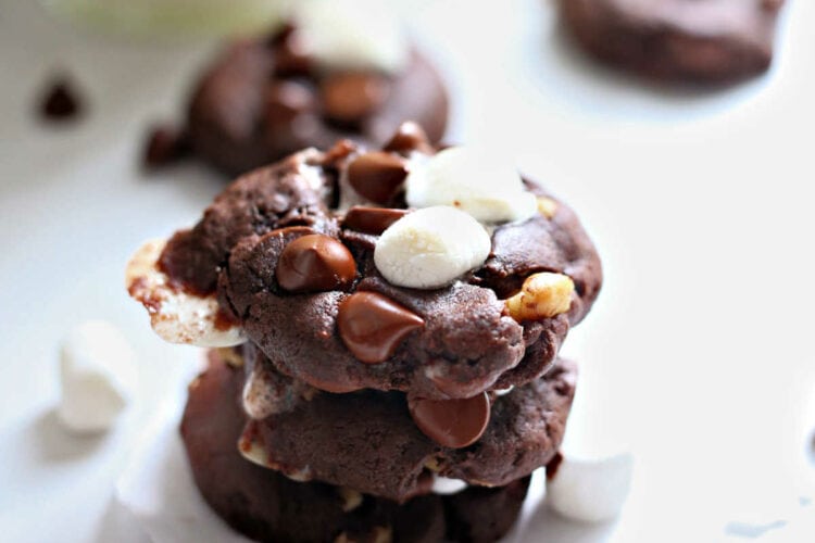 best rocky road cookies stacked on a table with a glass of milk