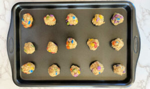 gluten-free monster cookie dough balls on a baking pan