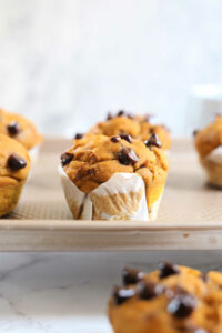 gluten free pumpkin chocolate chip muffins on a baking sheet