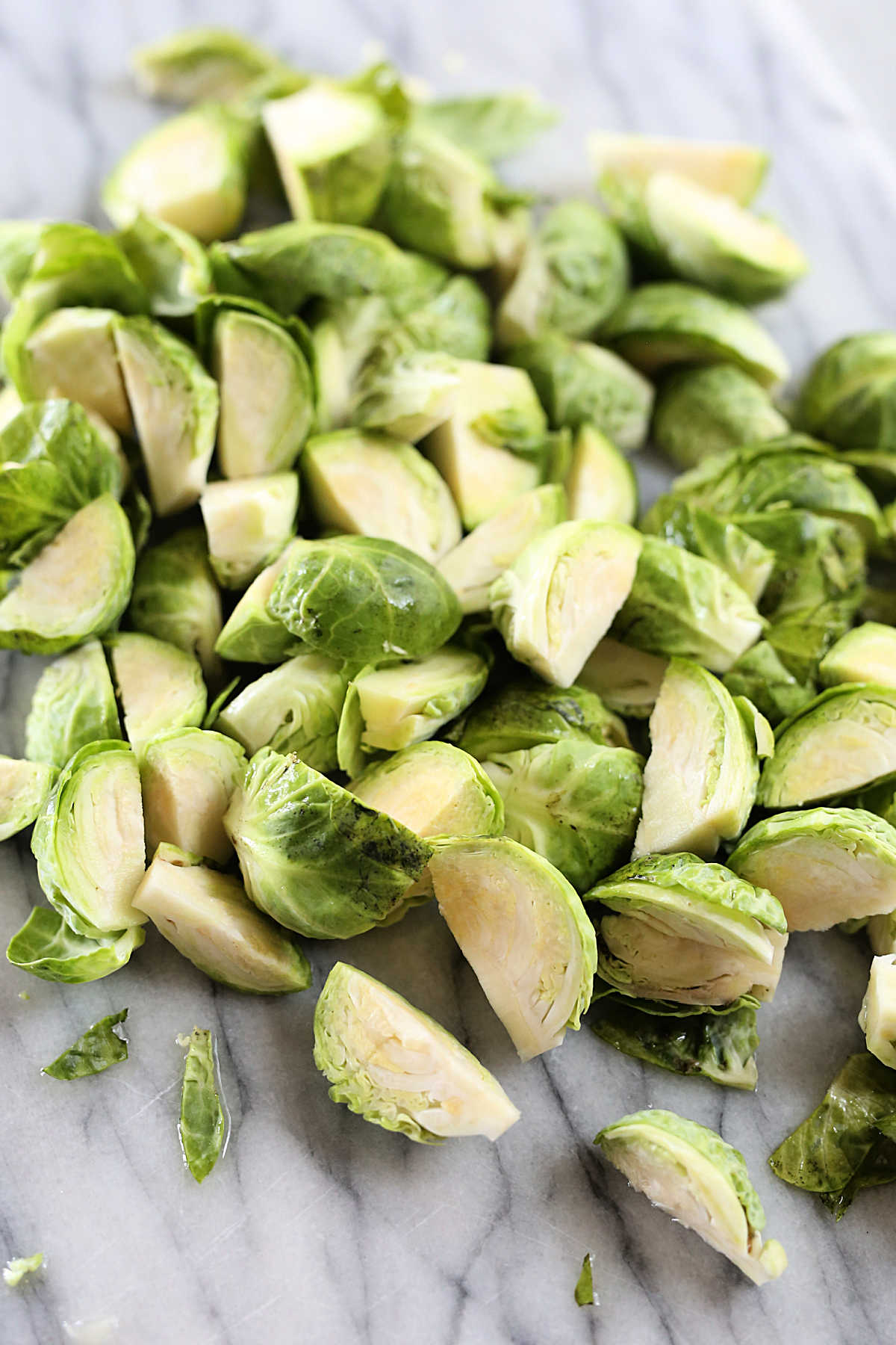 how to cut brussels sprouts with quartered vegetables on a cutting board