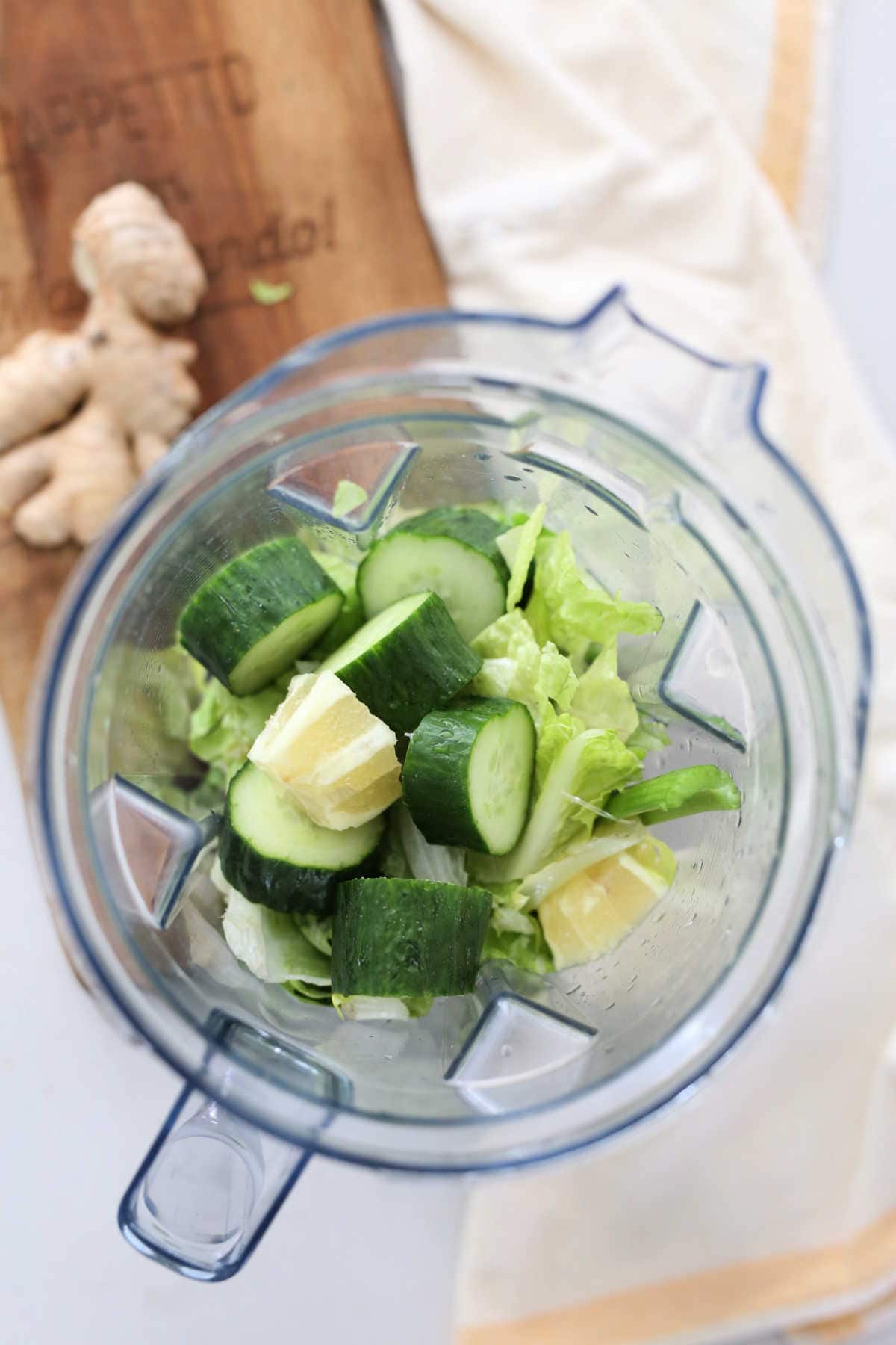 green vegetable juice ingredients chopped in a blender