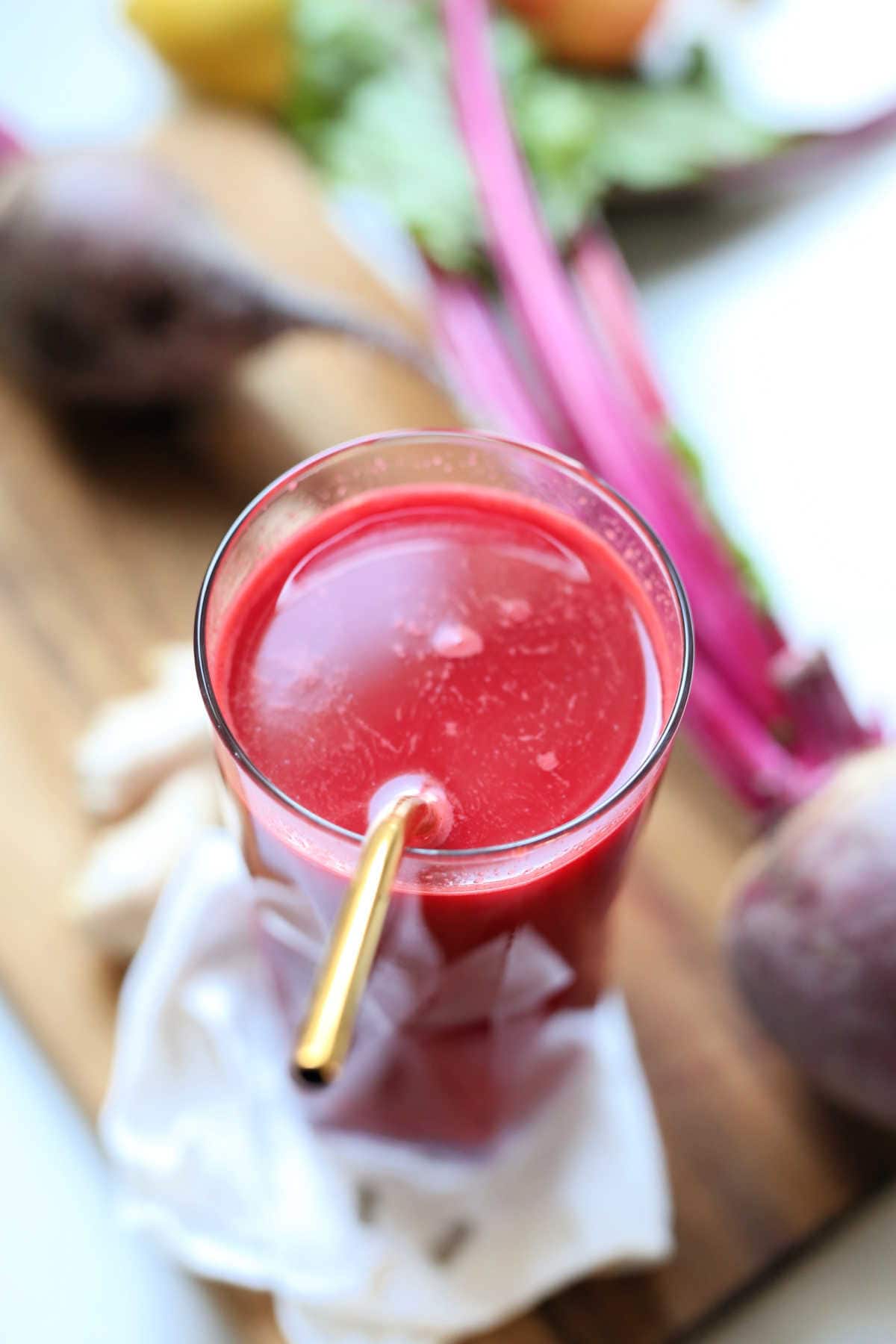 detox drink made of beet juice in a glass with a gold straw