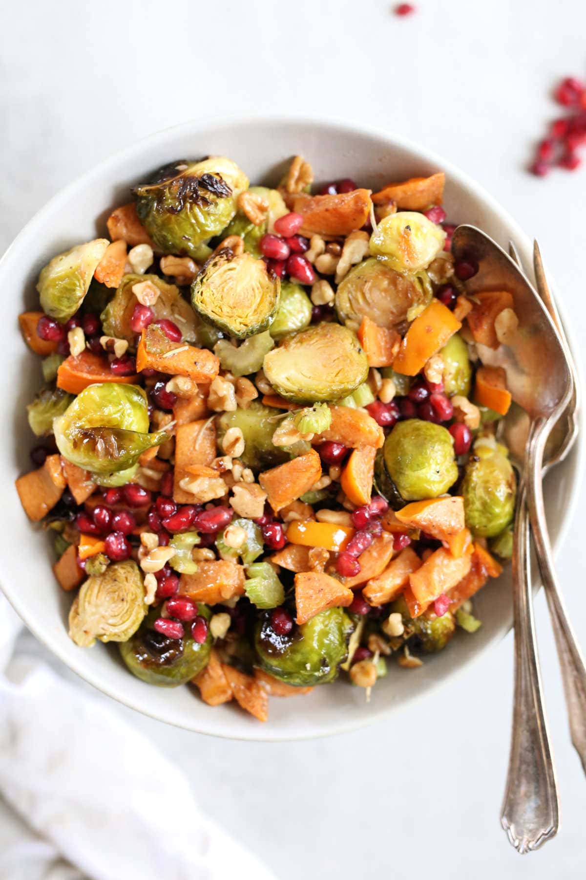 Roasted salad made with brussels sprouts in a bowl with a serving spoon and fork