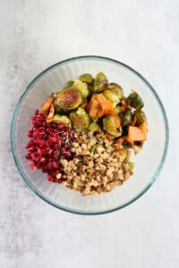 easy salad in a bowl made with brussels sprouts persimmon and pomegranates with maple dressing