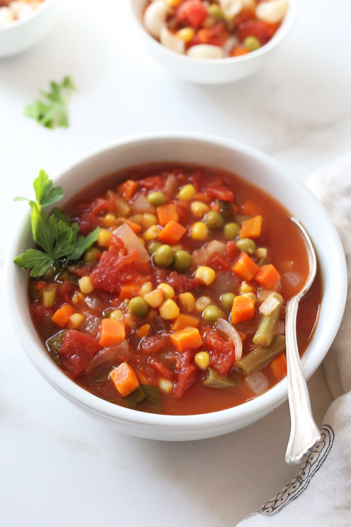 bowl of soup made of fresh and frozen vegetables in a tomato broth