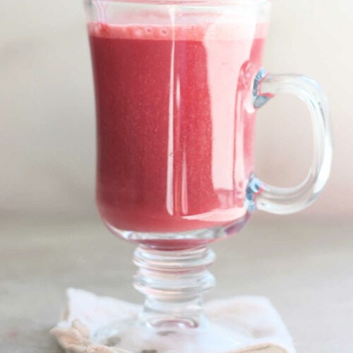 beet latte in a glass mug on a towel