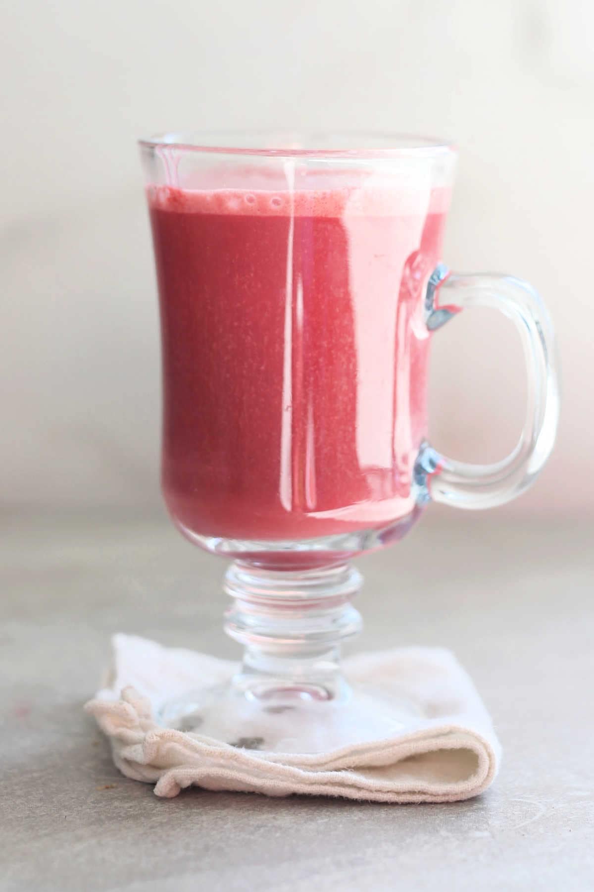 beet latte in a glass mug on a towel