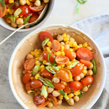 chickpea salad with tomatoes and corn in a bowl with a towel