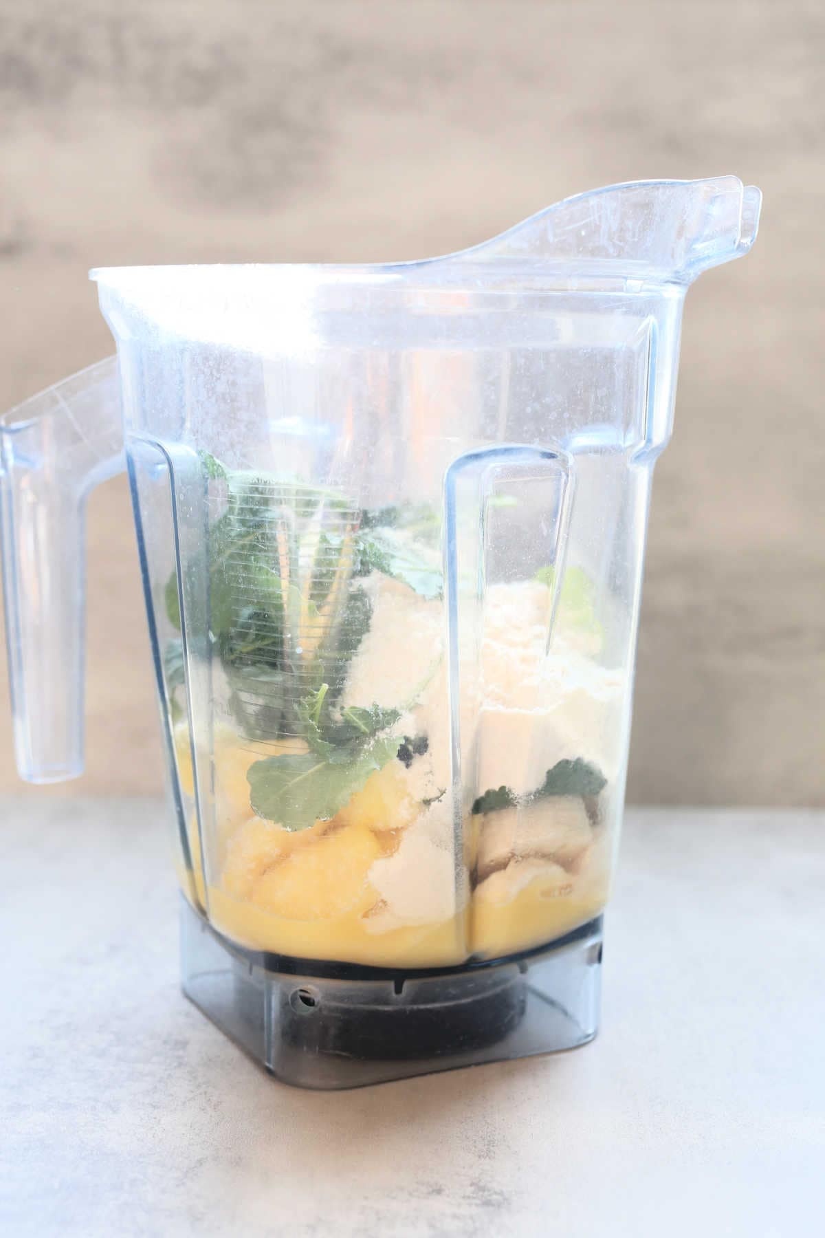 kale, protein powder, banana, pineapple, orange juice, in a Vitamix blender to make a smoothie